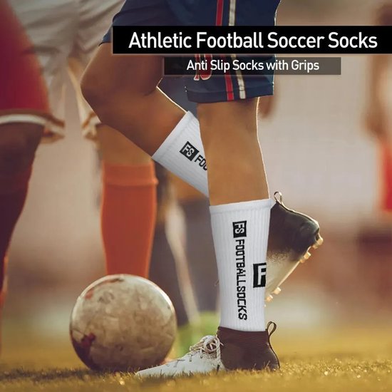 Voetballers met witte "FS FOOTBALL SOCKS" sokken en zwarte noppen op een grasveld.