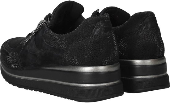 Achterkant van zwarte damessneakers met dikke zilveren zoolrand en textuur.