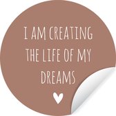 WallCircle - Muurstickers - Behangcirkel - Engelse quote "I am creating the life of my dreams" op een bruine achtergrond - 80x80 cm - Muurcirkel - Zelfklevend - Ronde Behangsticker