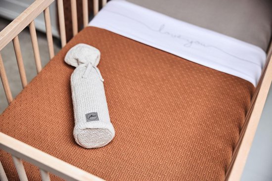 Wiegbekleding met een bruine deken en een beige cocon.