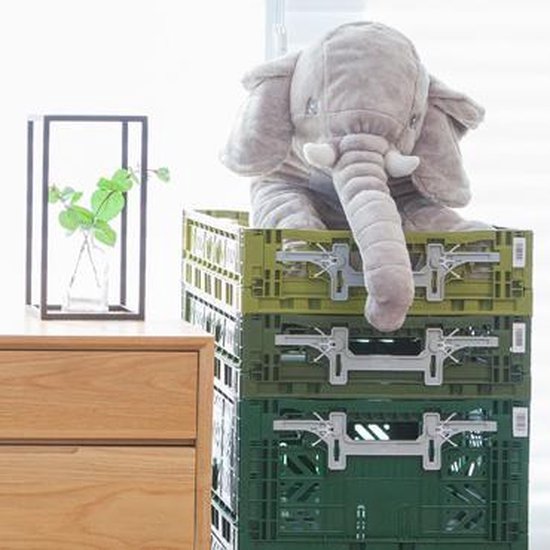 Een stapel van drie groene AyKasa kratten met een stoffen olifant die erin zit.