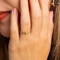 Gouden ring met delicates patroon op een vrouwelijk hand.