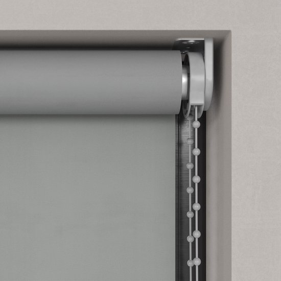 Close-up van de grijze bedieningsketting en rol van een rolgordijn.