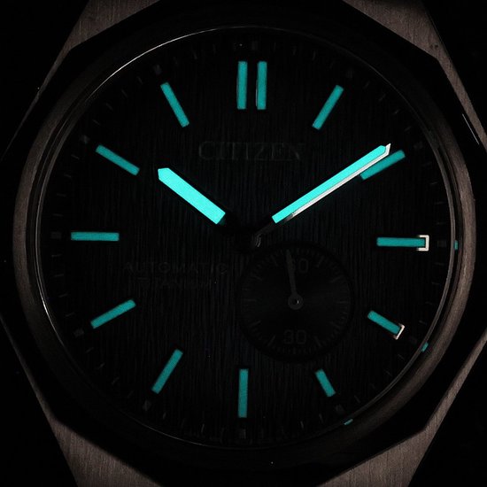 Citizen horloge met blauwe, verlichte wijzerplaat in het donker.