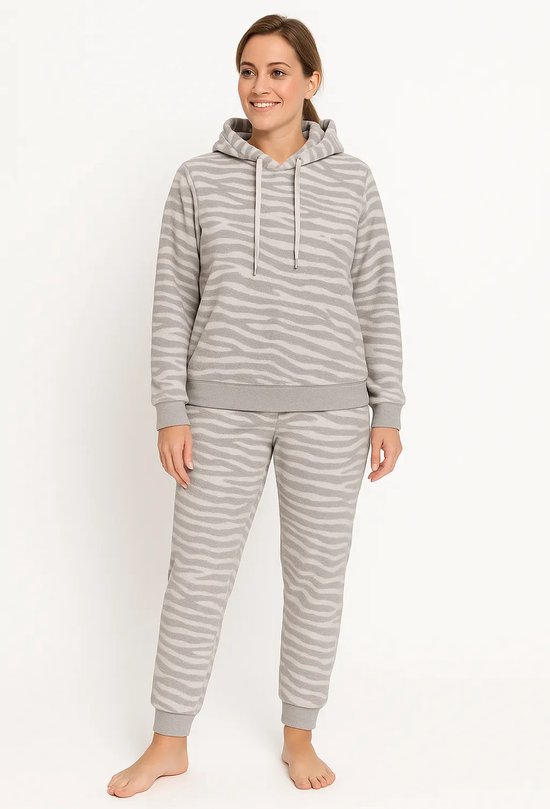 Vrouw in grijs fleece loungewear set met capuchon en zebraprint.