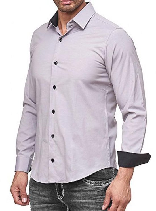 Man in lichtgrijs slim-fit overhemd met zwarte knopen en omgeslagen manchetten met zwarte binnenzijde.