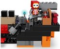 Figurine LEGO Minecraft avec tête rouge, armure grise et briques de construction aux accents orange et noirs.
