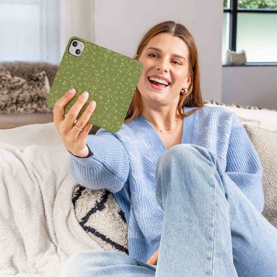 Vrolijke vrouw met een groen telefoonhoesje met bladerpatroon.