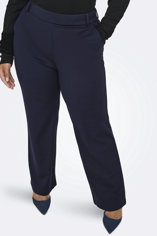 Detail van de voorkant van de donkerblauwe broek met wijde pijpen.