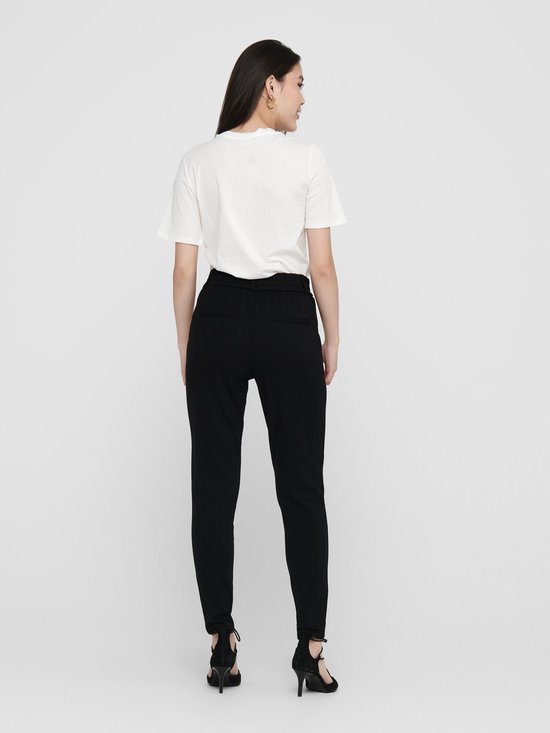 Zwarte chino broek met hoge taille, gedragen door een model in een wit t-shirt en zwarte pumps.