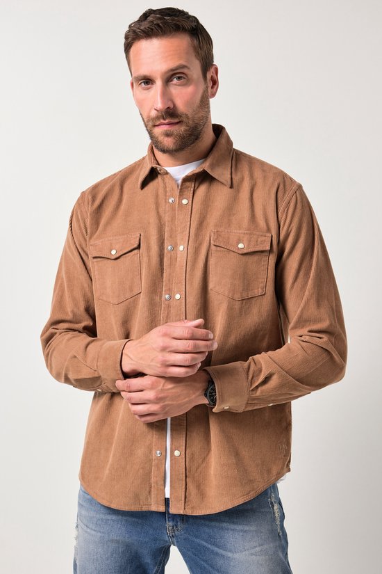 Model draagt een bruin corduroy overhemd met lange mouwen, twee borstzakken en een wit shirt eronder.