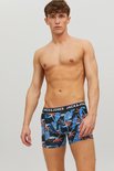 Zwarte boxershorts met blauwe tropische print van bladeren en bloemen. Blauwe band met 'JACK & JONES' logo, gedragen door een man.