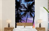 Behang - Fotobehang De kleurrijke zonsondergang achter een rij met palmbomen op Hawaï - Breedte 120 cm x hoogte 240 cm