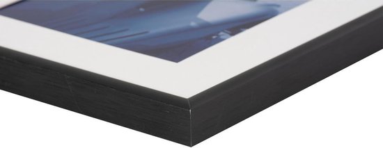 Close-up van de zwarte lijst van een fotolijst met witte passe-partout en blauwe print.