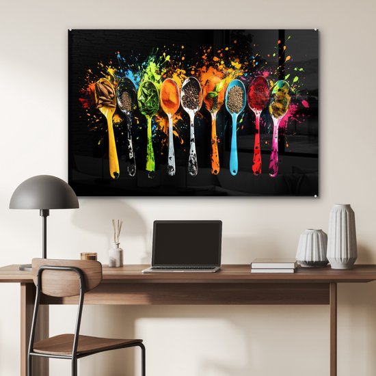Un panneau mural en verre avec une rangée de cuillères colorées remplies d'épices et d'herbes, avec des éclaboussures de peinture, au-dessus d'un bureau.