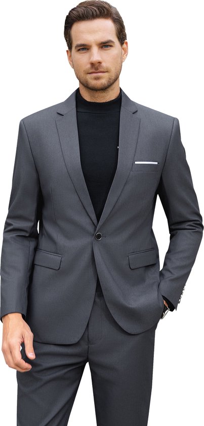 Man in grijs kostuumjasje over een zwarte coltrui, met grijze broek. Jasje met één knoop en borstzakje.
