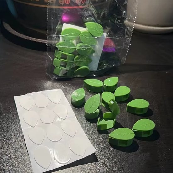 Verpakking met groene bladvormige plantenclips en een vel met 12 zelfklevende stickers.