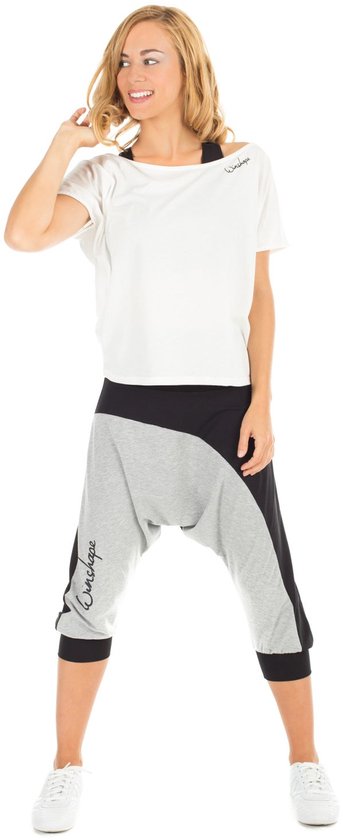 Model in wit t-shirt en grijze/zwarte capri broek met 'Winshape' logo.