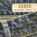 Label met 'GUARD REGULAR LOOSE FIT' op donkerblauwe jeans.
