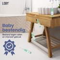 Mintgroene Loby tandenborstel op een houten badkamermeubel, met vallende zeepjes.