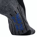 Dichtbij opname van een zwarte FALKE sok met grijze accenten en blauwe tekst.