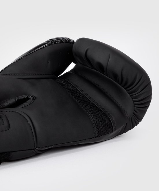 Detailopname van een zwarte Venum bokshandschoen, met mesh ventilatie.