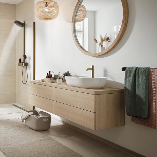 Moderne badkamer met houten wastafelmeubel, ronde spiegel, douche en gouden kraan.