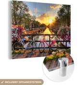 MuchoWow - Glasschilderij - Foto op glas - Amsterdam - Fiets - Bloemen - Zon - Roze - Acrylglas - Schilderij glas - 120x90 cm - Schilderij bloemen - Wanddecoratie - Muurdecoratie - Schilderijen woonkamer