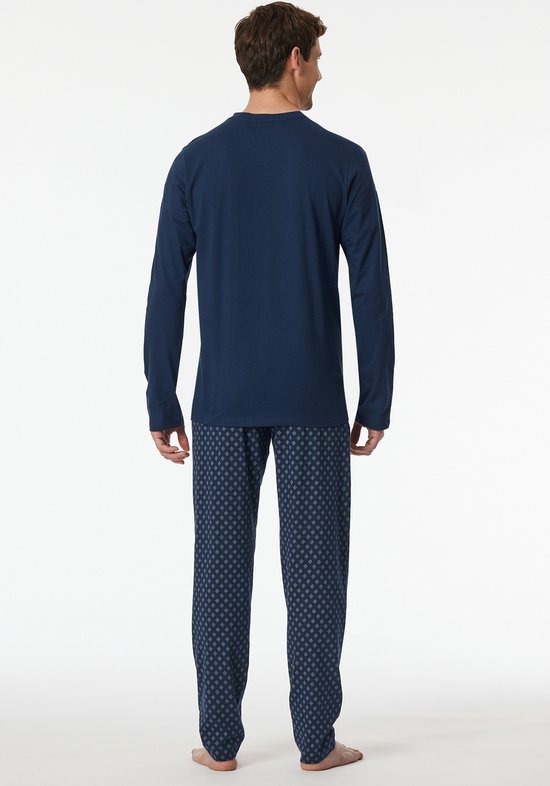 Man van achteren gezien, draagt een donkerblauwe pyjamaset.