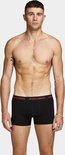 Een man met een gespierd bovenlichaam, draagt een zwarte JACK & JONES boxer short met rode tekst op de tailleband.