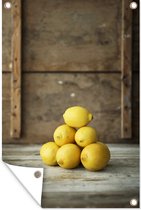 Tuinposter - Tuindoek - Tuinposters buiten - Stapel van gele citroenen voor een rustieke kist - 80x120 cm - Tuin
