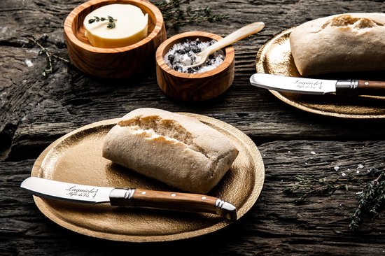 Twee Laguiole botermessen bij brood en boter.
