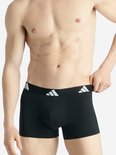 Man in zwarte Adidas boxershort, witte logo's op de band.