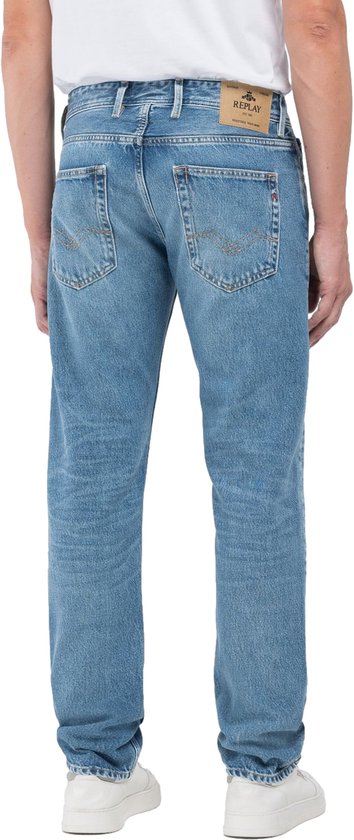 Lichtblauwe Replay jeans met een verweerde look, gedragen door een man.