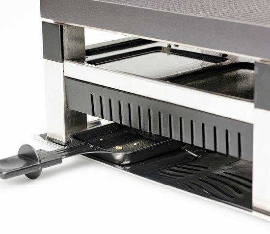 Bodem van een raclette grill met een zwart rooster en uitschuifbare pannetjes.