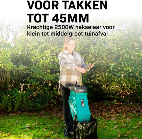 Vrouw in geruite blouse gebruikt een groene hakselaar met opvangzak. "Voor takken tot 45mm. Krachtige 2500W hakselaar voor klein tot middelgroot tuinafval."