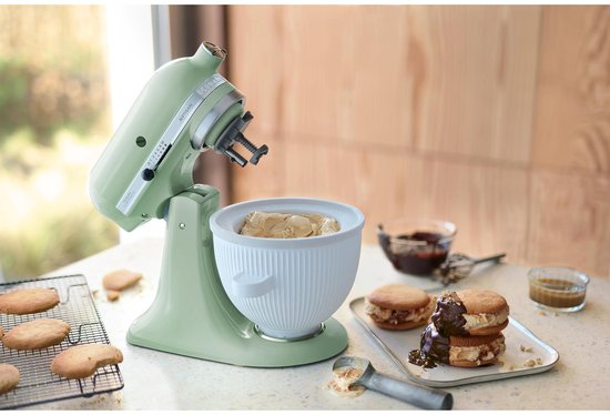 Pistachekleurige KitchenAid keukenmachine met ijsschepkom en een opgemaakte toren van ijsjesbroodjes.