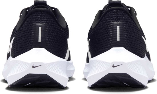 Achterkant van twee zwarte Nike sportschoenen met witte zolen en logo's.