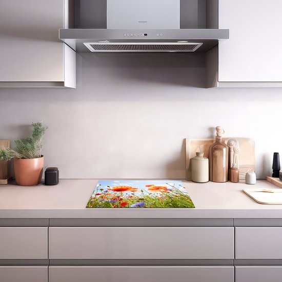Een inductiebeschermer met een bloemenprint, geplaatst op een aanrecht in een moderne keuken.
