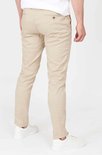 Achterkant van een mannen chino in lichtbeige, gedragen met witte sneakers.