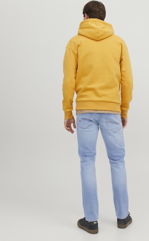 Model van achteren, draagt lichtblauwe slim fit jeans met karakteristieke stiksels op de achterzakken.