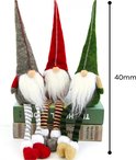 Trois nains de Noël avec des bonnets pointus gris, rouges et verts, des barbes blanches et des jambes rayées.