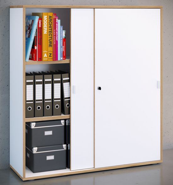 Witte kast met houten accenten en schuifdeuren, geplaatst tegen een grijze betonnen muur, gevuld met mappen en boeken.