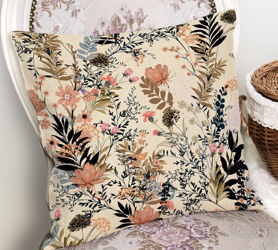 Beige sierkussen met bloemenpatroon in roze, oranje en blauwe tinten, op een stoel.