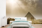 Behang - Fotobehang De Sfinx van Gizeh en piramide in een zandstorm - Breedte 450 cm x hoogte 300 cm