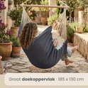 Vrouw met krullend haar zit in een donkerblauwe hangstoel, groot doekoppervlak van 185x130 cm.