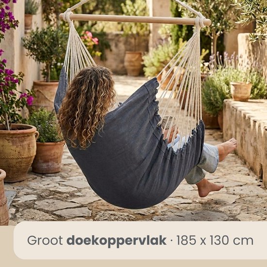 Vrouw met krullend haar zit in een donkerblauwe hangstoel, groot doekoppervlak van 185x130 cm.