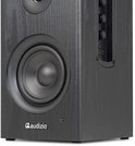 Close-up van een zwarte houten boekenplank speaker, met focus op de woofer en bedieningsknoppen aan de zijkant.