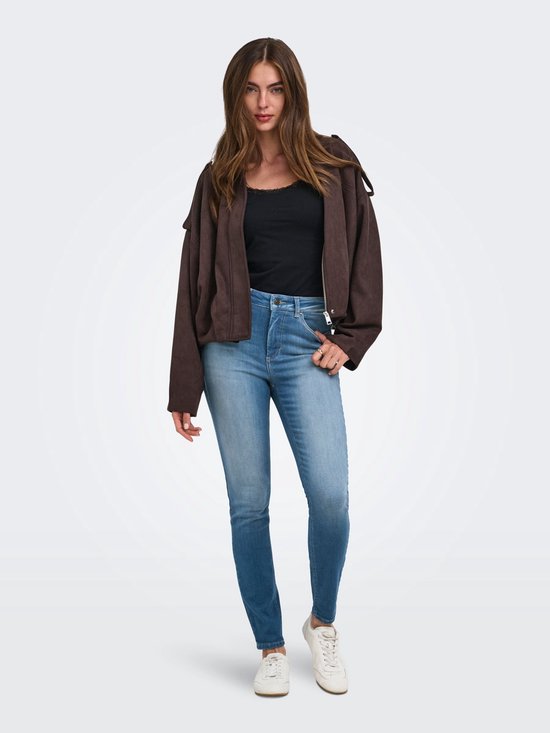 Model draagt een skinny jeans met hoge taille en een bruin jasje en zwart topje.