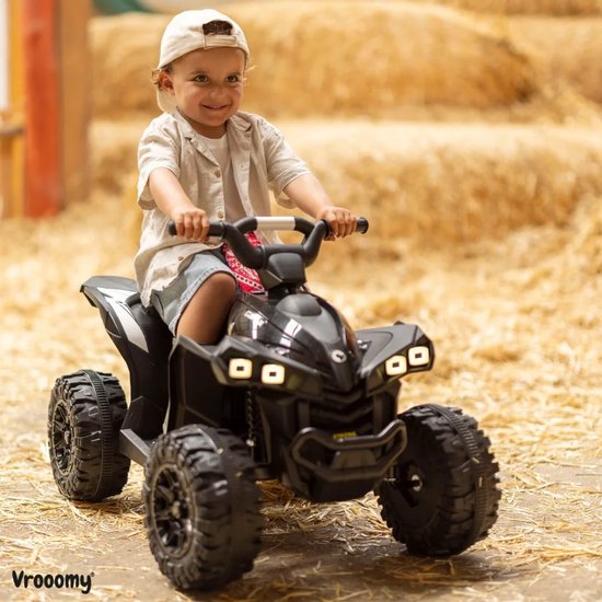 Zwarte kinderquad met een jongetje erop. De quad heeft robuuste wielen en een scherpe, sportieve vormgeving.